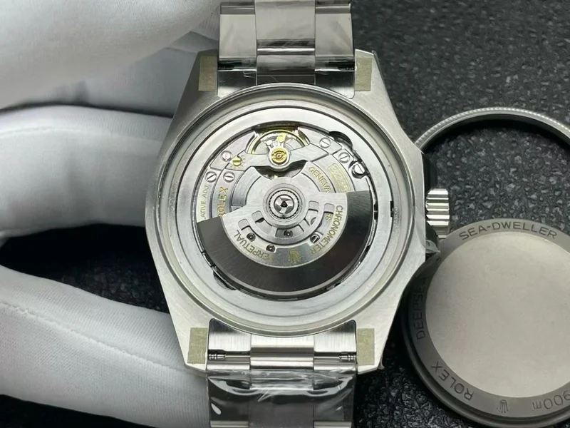 Movement with the caseback removed, the caseback set beside it