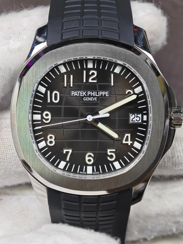 Charcoal sunray embossed dial and steel case on a black strap, front view, held in a white glove