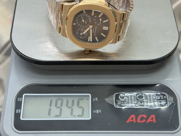 UMI Nautilus 5712/1R, brown dial, gold-plated bracelet, on a scale