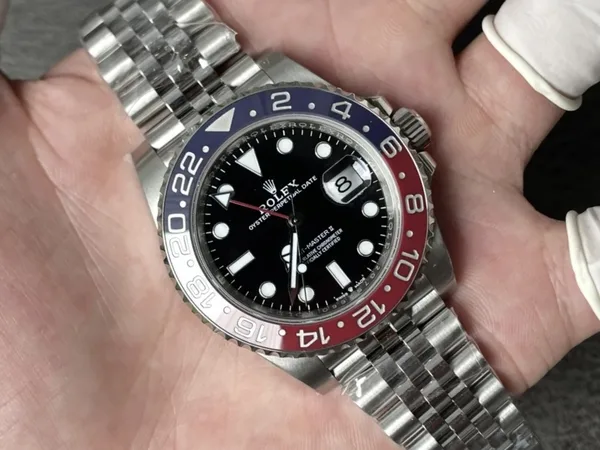 Rich Factory GMT-Master II 126710BLRO Pepsi, black dial, red and blue bezel, jubilee-style bracelet, held in the hand
